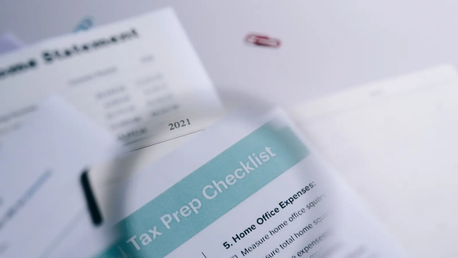 Checklist de vérification posée sur un état financier, agrafes de classement à proximité